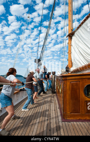 L'équipage sur une goélette en bois historique lors d'une course au Port Townsend Wooden Boat Festival à l'État de Washington, USA. Banque D'Images