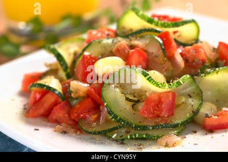 Tranches de courgettes sautées, cubes de tomate, l'oignon et les grains de maïs cuit avec des herbes séchées et poivre noir Banque D'Images