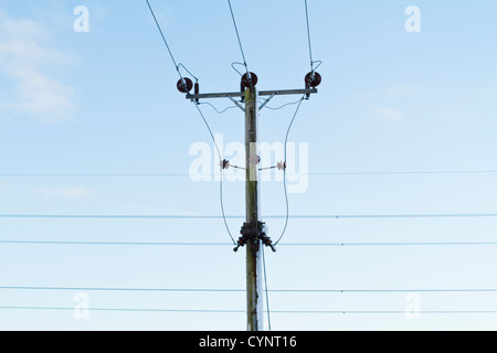 Les lignes d'alimentation et de distribution d'électricité poteau en hiver avec de la neige soufflée contre un côté, Lancashire, England, UK Banque D'Images