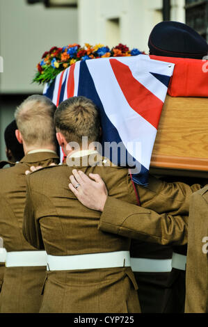 Des soldats en uniforme portent un cercueil d'un collègue, drapé d'une Union Jack Banque D'Images