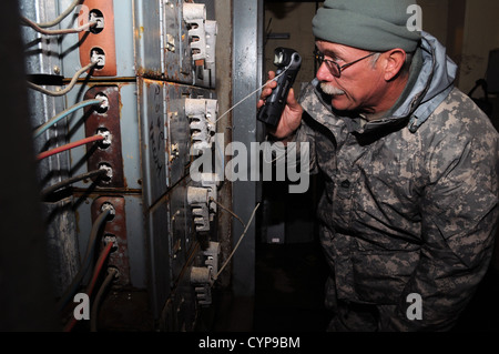Le Sgt. 1re classe Marty Newman, de la W.Va. La Garde nationale d'armée 3664th Maintenance, inspecte les panneaux électriques endommagés dans le sous-sol d'un complexe d'appartements à Brooklyn que inondé lors de l'Ouragan Sandy. Plus de 10 pieds de l'eau de mer les inondations cau Banque D'Images