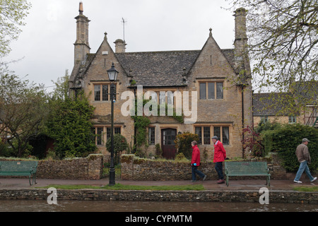 Jolie maison mitoyenne en pierre à côté de la rivière Windrush dans le village de Cotswold Bourton On The Water, Gloucestershire, Royaume-Uni. Banque D'Images