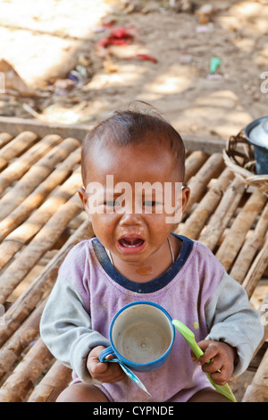 Très malheureux petit Bébé garçon dans le village sur pilotis Kampong Khleang dans le nord du Cambodge Banque D'Images