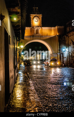 Santa Catalina Arche rue pavée nuit Antigua Guatemala // L'arche au-dessus de la rue du couvent de Santa Catalina dans le centre d'Antigua, Guatemala, avec l'eau de la pluie récente reflétant les lumières sur la rue pavée. Banque D'Images