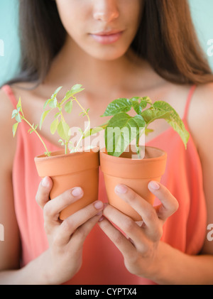 Hispanic teenager holding potted plants Banque D'Images