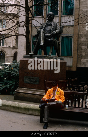 Un commerçant de la LIFFE futures exchange prend une pause dans la rue au cours d'un midi en semaine sous George Peabody statue Banque D'Images