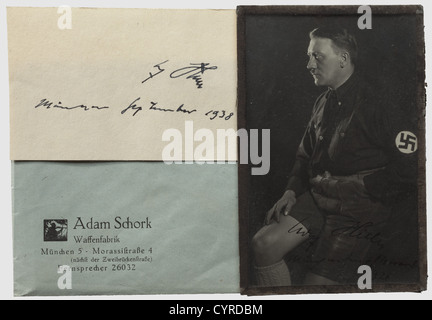 Adolf Hitler - Adam Schork, une photo de portrait signée de 1926 photo de début par Hoffmann, Hitler dans lederhosen, signé à la limite inférieure 'Adolf Hitler - München den 6/Novembre 1926', une carte de visite d'Adam Schork à l'envers. Un autre autographe 'Adolf Hitler - München septembre 1938' sur une carte de vœux dans un 'Wechselrahmen für Ansichtskarten. Hoch und quer zum Hängen' (cadre photo clip-on pour cartes postales. A placer verticalement et horizontalement) avec l'avant galsé et en conséquence imprimé verso. Le cadre a été enveloppé dans la société de porc pap, Banque D'Images