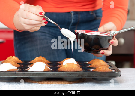 Jeune femme dans la cuisine faire des muffins Banque D'Images