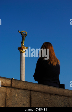 L'Ukraine. Kiev. Femme à la colonne de l'indépendance avec statue de l'Archange Michael. Banque D'Images