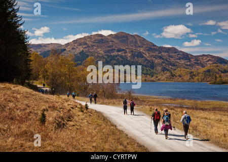 Un club de randonnée dans la forêt, au bord du Loch Achray Achray. Ben la salle est dans l'arrière-plan. Banque D'Images