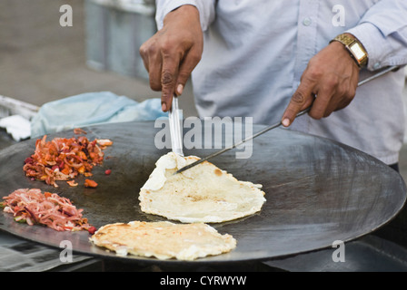 L'homme préparer egg roll dans une stalle, New Delhi, Inde Banque D'Images