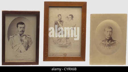 Deux photos-cadeaux du tsar Nicholas II et de la famille impériale russe, Russie, datant de 1892 et CA. 1900 photo Portrait du futur tsar avec sa signature manuscrite à l'encre. Le bord droit avec la signature en relief du photographe de terrain 'Levitsky'. Le dos avec le nom du photographe imprimé en or. Portrait de la famille impériale avec l'identification du photographe 'Levitsky, Saint-Pétersbourg'. Légèrement taché. Les deux sous verre, dans un cadre en bois, dimensions de cadre 17,2 x 11,5 cm et 18,7 x 13,2 cm. Aussi une photo de portrait tôt de Grand Duke Pavel Alexdr, Banque D'Images