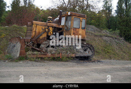 Vieux jaune sale bulldozer dans la forêt Banque D'Images