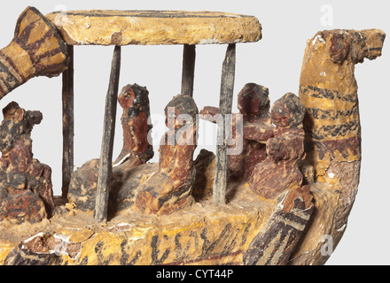 Un funéraire égyptien, période tardive, du 7ème au 1er siècle C.-B. Bois avec un revêtement en plâtre peint en couleur. Un bateau en trois dimensions avec quatre oars sur les côtés. Il y a quatre figures avec un sarcophage sous un baldachin sur le pont. Anubis, le Dieu de la mort, est assis dans la poupe. Longueur 33 cm. Certains dégâts et écaillage de la peinture. Provenance: Marchand d'art italien, historique, historique, gens, monde antique, monde antique, temps antique, objet, objets, alambics, coupure, découpe, découpes, Méditerranée, métaux précieux, métaux précieux, droits additionnels-Clearences-non disponible Banque D'Images