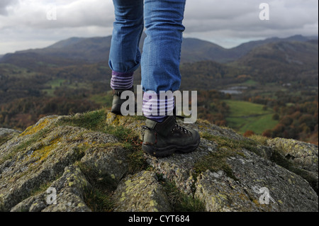 Vues autour de Loughrigg est tombé près de Ambleside Lake District femme en bottes de marche en montant vers le haut sur la journée d'automne Banque D'Images