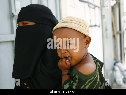 Mère yéménite portant Niqab et tenant un bébé sur la hanche, Tarim, au Yémen Banque D'Images