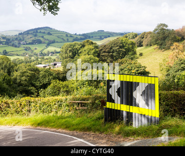 Virage dangereux en route avec des signes de flèche dans la campagne du Pays de Galles Banque D'Images