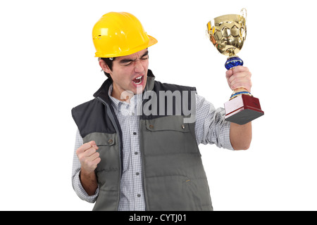 Homme builder holding trophy Banque D'Images