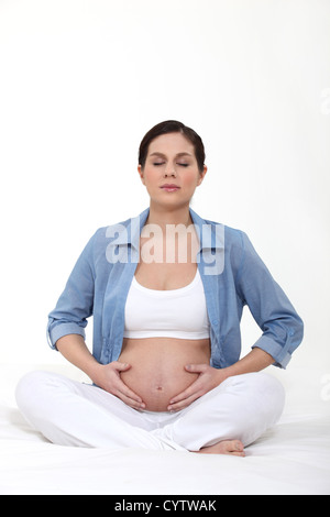 Pregnant woman practicing yoga Banque D'Images