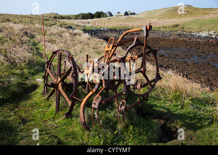 Rusty old farm machinery abandonnés dans un champ près de Flodaigh Benbecular sur, Hébrides extérieures, en Écosse, Royaume-Uni Banque D'Images