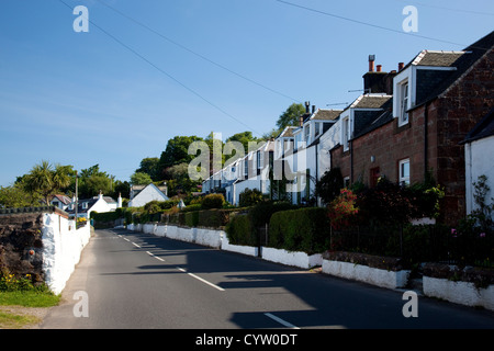 Vue sur une rangée de maisons le long de la route dans le village côtier de Corrie, Isle of Arran, Ecosse, Royaume-Uni Banque D'Images