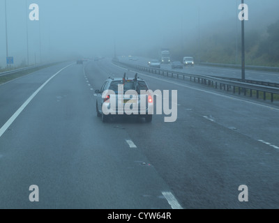 Un assemblage de véhicules de transport dans le trafic de brouillard sur une autoroute du Royaume-Uni dans le Nord de l'Angleterre. Banque D'Images