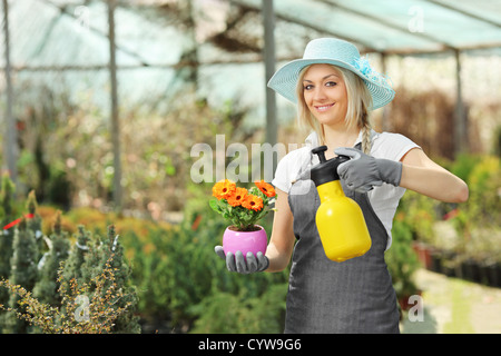 Une belle femme latin une plante dans une serre Banque D'Images