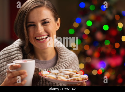 Happy woman holding tasse de chocolat chaud avec des guimauves et la plaque de biscuits de Noël Banque D'Images