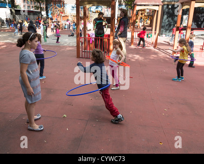 Les enfants avec hula hoop, aire de Tecumseh, West 78th Street et Amsterdam Avenue, Manhattan, New York City, USA Banque D'Images