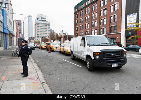 Femme agent de police véhicule de surveillance des pompes à l'accès à l'ouest de la station de Manhattan, le 10 novembre 2012, le 2e jour de rationnement du gaz dans la ville de New York aux États-Unis. Arrêtés du maire Michael Bloomberg et le gouverneur Andrew Cuomo restreindre par des propriétaires privés pour l'achat du carburant pour leurs véhicules sur l'étrange- ou les jours, selon le dernier chiffre de leurs numéros de licence. Les véhicules commerciaux sont exonérées. Banque D'Images