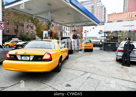 Femme agent de police véhicule de surveillance des pompes à l'accès à l'ouest de la station de Manhattan, le 10 novembre 2012, le 2e jour de rationnement du gaz dans la ville de New York aux États-Unis. Arrêtés du maire Michael Bloomberg et le gouverneur Andrew Cuomo restreindre par des propriétaires privés pour l'achat du carburant pour leurs véhicules sur l'étrange- ou les jours, selon le dernier chiffre de leurs numéros de licence. Les véhicules commerciaux sont exonérées. Banque D'Images