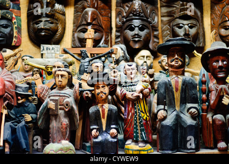 Figurines en bois de Saint Simon Antigua Guatemala | ANTIGUA GUATEMALA, Guatemala — Figurines en bois de Saint Simon (également connu sous le nom de Maximón) et d'autres personnages traditionnels exposés à la vente dans un marché local à Antigua Guatemala. Les figurines représentent des symboles culturels et religieux importants dans les traditions populaires guatémaltèques. Antigua Guatemala, fondée au début du XVIe siècle, a servi de capitale du Royaume du Guatemala jusqu'en 1773 lorsqu'elle a été largement détruite par un tremblement de terre. La ville est réputée pour son architecture baroque espagnole bien préservée et ses nombreuses ruines d'églises coloniales. Désignée Banque D'Images