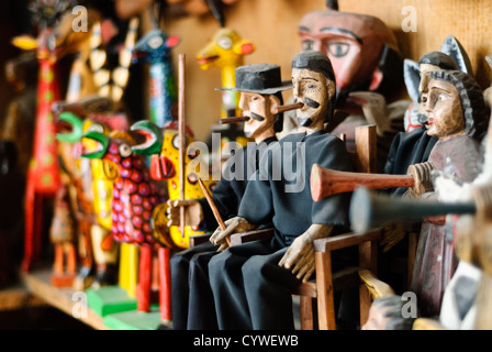 Marché des figurines de Saint Simon Antigua Guatemala | ANTIGUA GUATEMALA, Guatemala — Figurines en bois de Saint Simon (également connu sous le nom de Maximón) et d'autres personnages traditionnels exposés à la vente dans un marché local à Antigua Guatemala. Les figurines représentent des symboles culturels et religieux importants dans les traditions populaires guatémaltèques. Antigua Guatemala, fondée au début du XVIe siècle, a servi de capitale du Royaume du Guatemala jusqu'en 1773, date à laquelle elle a été largement détruite par un tremblement de terre. La ville est réputée pour son architecture baroque espagnole bien préservée et ses nombreuses ruines d'églises coloniales. Désignée Banque D'Images