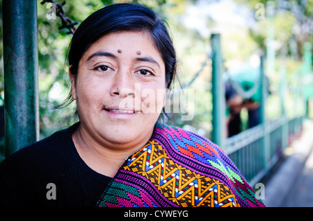 Tisseuse guatémaltèque avec textile Antigua Guatemala // ANTIGUA, Guatemala — Une tisseuse expose ses textiles artisanaux à vendre, avec une de ses créations tissées drapée sur son épaule. Antigua, site classé au patrimoine mondial de l'UNESCO dans les hauts plateaux du centre du Guatemala, est réputée pour ses traditions textiles indigènes dynamiques qui se sont transmises de génération en génération. La ville sert de centre majeur pour le tissage traditionnel guatémaltèque, où les artisans créent des tissus colorés en utilisant des techniques qui datent de plusieurs siècles. Les tisserands locaux vendent souvent leurs produits faits à la main dans les marchés et dans les rues à travers le Banque D'Images