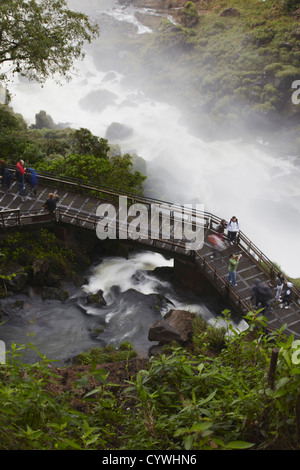 Les touristes crossing bridge au pied de chutes Bossetti, Iguazu, Iguazu National Park, Misiones, Argentine Banque D'Images