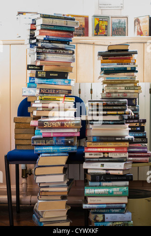 Une pile de manuels scolaires et de romans dans la bibliothèque d'une école secondaire au Pays de Galles, Royaume-Uni Banque D'Images