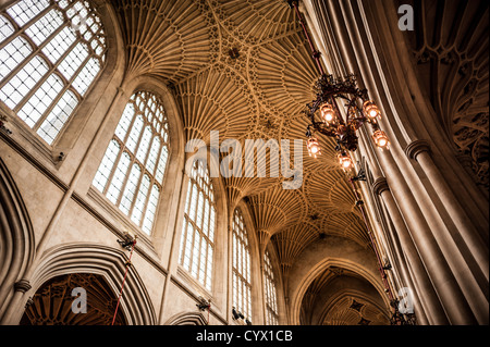 BATH, Royaume-Uni — le magnifique plafond voûté en éventail de la nef de l'abbaye de Bath met en valeur les pierres complexes de l'architecture gothique anglaise médiévale tardive. Anciennement connue sous le nom d'église abbatiale de Saint-Pierre et Saint-Paul, cette église paroissiale anglicane présente des éléments de conception gothique perpendiculaires distinctifs datant de sa reconstruction du XVIe siècle. La forme actuelle de l'église représente en grande partie la vision d'Oliver King, évêque de Bath and Wells, qui a initié la reconstruction vers 1499, bien que l'importance religieuse du site remonte à un monastère du VIIe siècle et plus tôt normand Banque D'Images