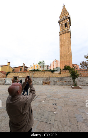 Un touriste photographiant la célèbre Campanile (clocher) de San Martino Église sur l'île vénitienne de Burano Banque D'Images