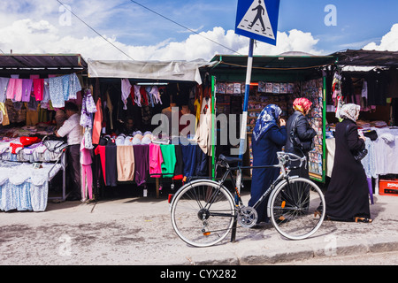 Les femmes musulmanes du shopping dans le vieux bazar de vêtir étals. Carsija district, Skopje, Macédoine Banque D'Images