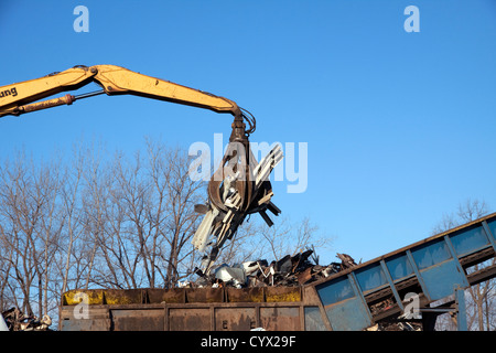 Grue grappin laissant tomber des objets métalliques à l'usine de recyclage de métal shredder E USA Banque D'Images