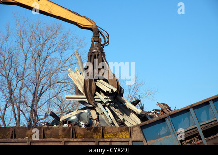 Grue grappin laissant tomber des objets métalliques à l'usine de recyclage de métal shredder E USA Banque D'Images