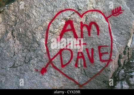 L'amour vrai coeur et Romance - noms et initiales de l'écrit dans la peinture rouge sur un rocher - Heart-Shaped Dessin Graffiti Romantique Banque D'Images