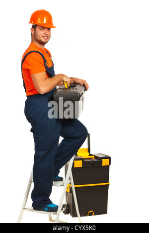 Cheerful workman debout sur l'escabeau et holding box isolé sur fond blanc Banque D'Images