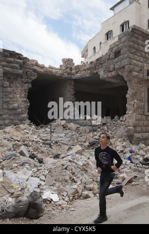 Un enfant passe devant l'école bombardée en Fardos. C'était très calme avec un manque notable de coups et de mortiers et de nombreuses personnes ont été Banque D'Images