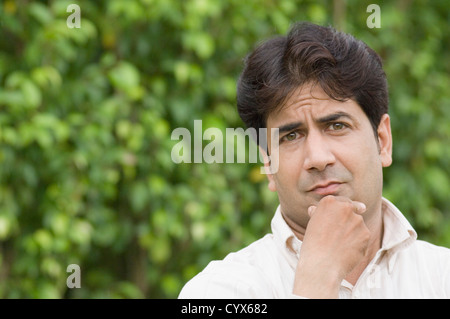 Portrait d'un homme pensant dans un parc Banque D'Images