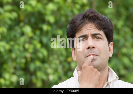 Portrait d'un homme pensant dans un parc Banque D'Images