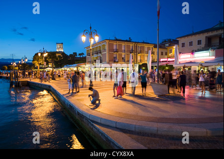 Les gens qui marchent sur la romantique promenade de la petite ville de Lazise au lac de Garde en Italie Banque D'Images