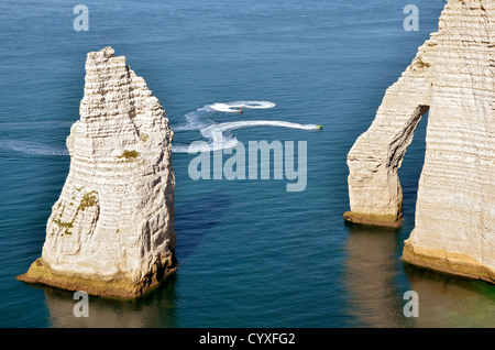 Célèbres falaises avec l'aiguille et l'arche naturelle la "Porte d'Aval" à Etretat. Deux jet ski sur la mer. Etretat est un Banque D'Images