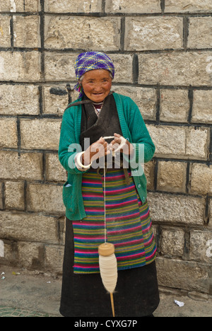 Vieille Femme tibétaine filage de la laine, Tibet, Chine Banque D'Images