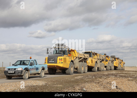 Convoi de camions à benne Volvo jaune utilisé pour redistribuer les cailloux sur la plage de galets des plages de sable de camion Rive Station Touristique Banque D'Images